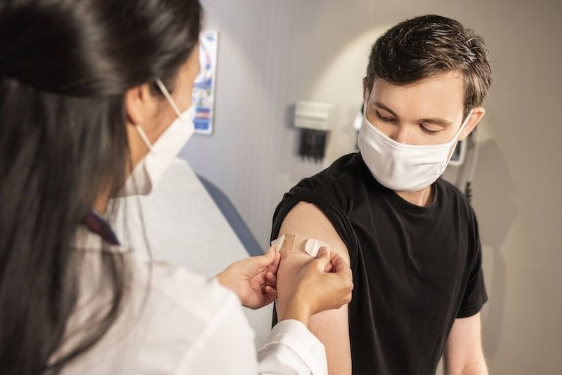 médica vacunando a un joven 